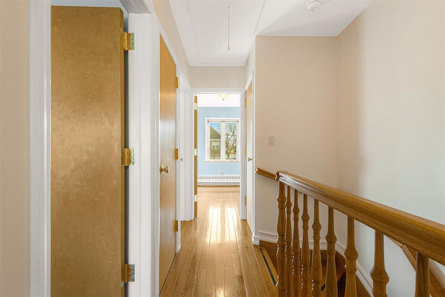 corridor with baseboard heating and light hardwood / wood-style flooring