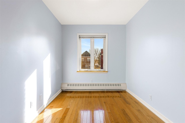 spare room featuring light hardwood / wood-style floors and a baseboard heating unit