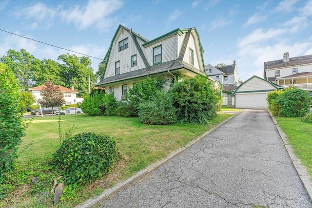 view of front of home with an outbuilding, a garage, and a front lawn