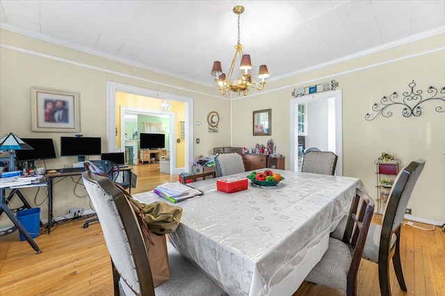 dining room featuring an inviting chandelier, crown molding, and light hardwood / wood-style flooring