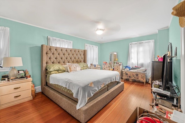 bedroom featuring crown molding, hardwood / wood-style floors, and ceiling fan