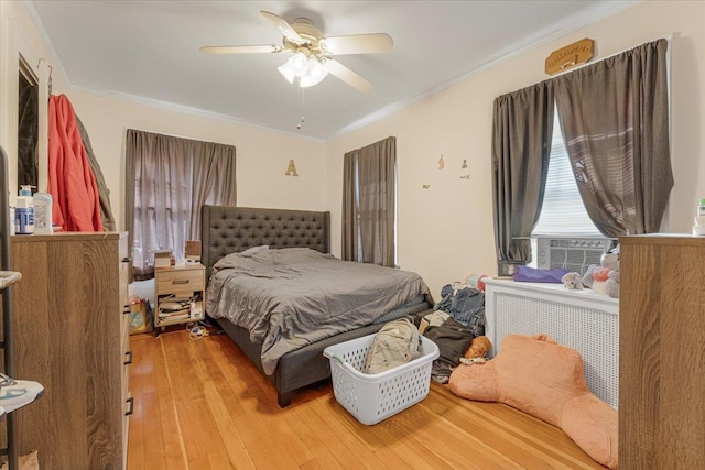 bedroom with cooling unit, ceiling fan, ornamental molding, and light wood-type flooring