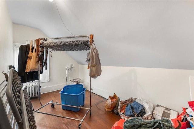 interior space featuring lofted ceiling, dark wood-type flooring, and radiator heating unit