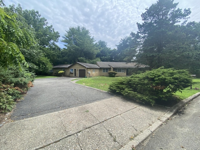 ranch-style house featuring a front yard and a garage