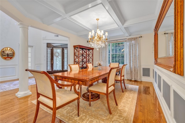 dining space featuring beam ceiling, coffered ceiling, a notable chandelier, decorative columns, and light hardwood / wood-style floors