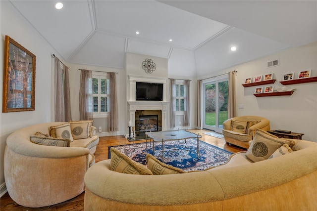 living room featuring wood-type flooring, lofted ceiling, and ornamental molding