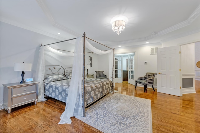 bedroom with french doors, hardwood / wood-style flooring, and crown molding