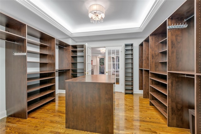 walk in closet featuring a chandelier and light hardwood / wood-style floors