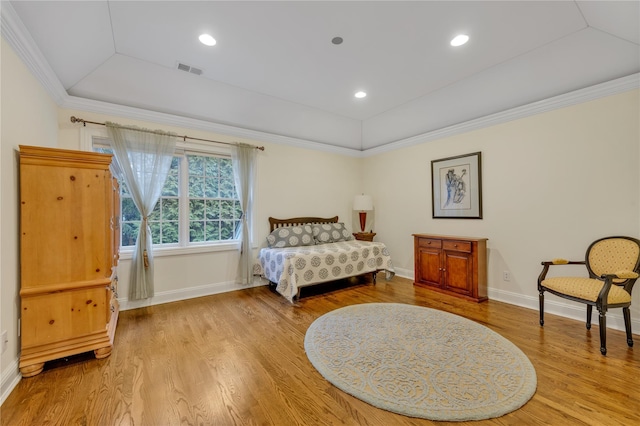 bedroom featuring a tray ceiling, light wood-type flooring, lofted ceiling, and ornamental molding