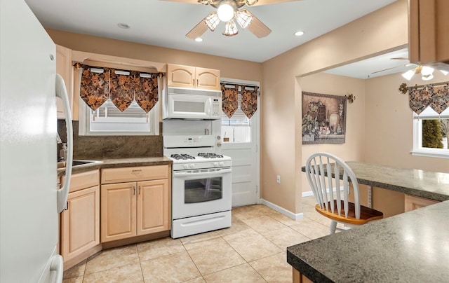 kitchen with light brown cabinets, white appliances, ceiling fan, light tile patterned floors, and backsplash