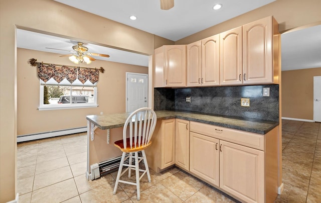 kitchen with baseboard heating, kitchen peninsula, tasteful backsplash, and light tile patterned floors