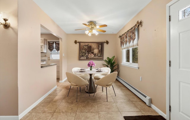 tiled dining room featuring a wealth of natural light, ceiling fan, and a baseboard radiator