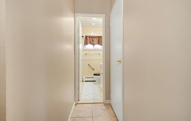 hallway with a baseboard radiator and light tile patterned floors