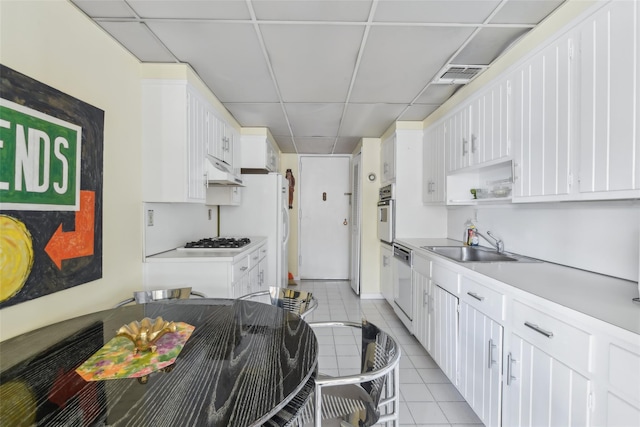 kitchen with white cabinetry, sink, and light tile patterned floors