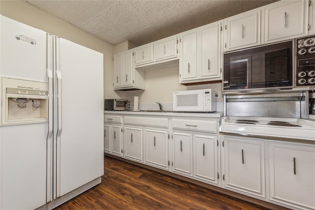 kitchen featuring white appliances, white cabinetry, and dark wood-type flooring