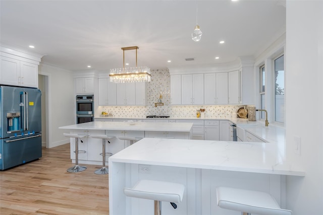 kitchen featuring white cabinetry, pendant lighting, a breakfast bar, and appliances with stainless steel finishes