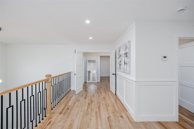 corridor featuring light hardwood / wood-style flooring and ornamental molding