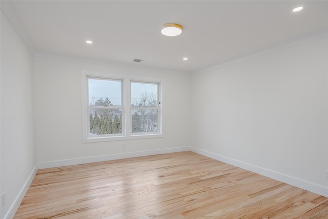 spare room featuring ornamental molding and light hardwood / wood-style floors