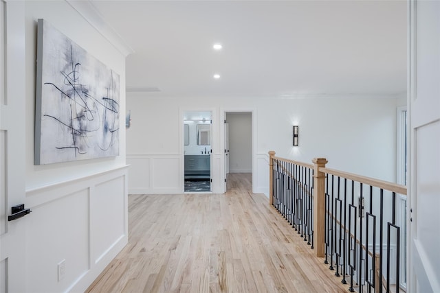 hallway featuring crown molding and light hardwood / wood-style flooring