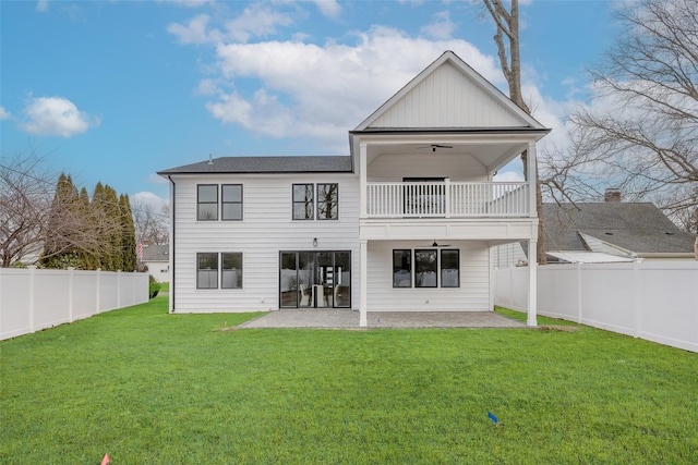 rear view of house featuring a patio, a balcony, ceiling fan, and a lawn