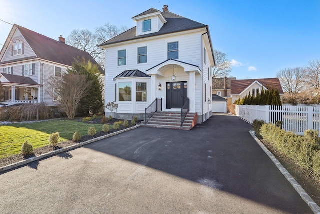 view of front of property featuring a garage, an outdoor structure, and a front yard