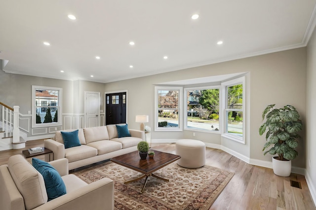 living room with light hardwood / wood-style flooring and ornamental molding