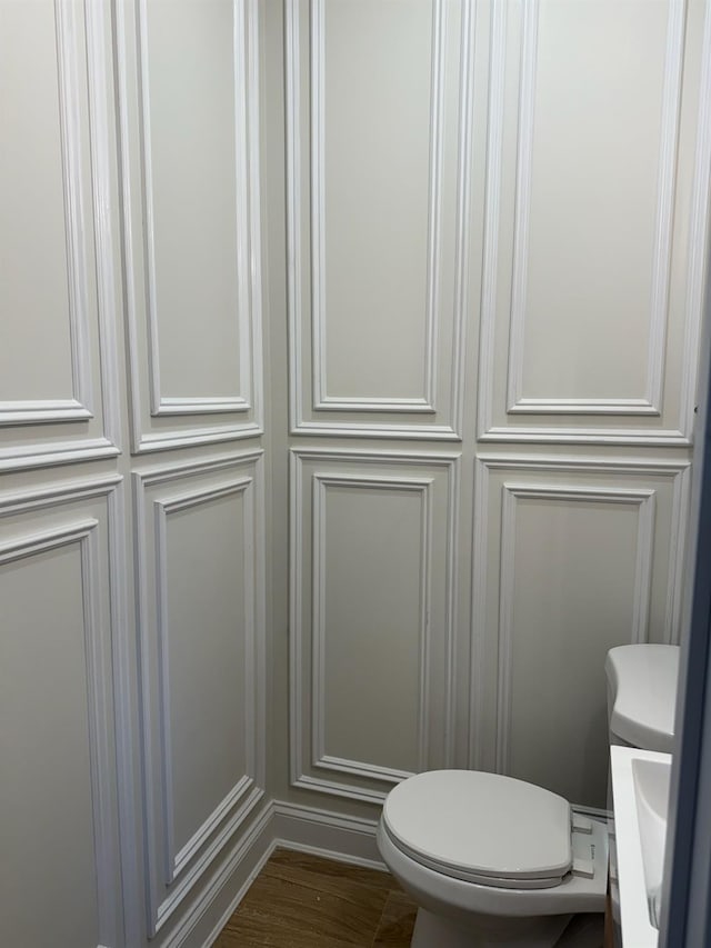 bathroom with hardwood / wood-style flooring and toilet