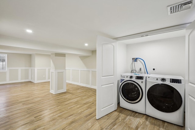 laundry room with light wood-type flooring and separate washer and dryer