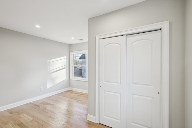 unfurnished bedroom featuring light hardwood / wood-style flooring and a closet