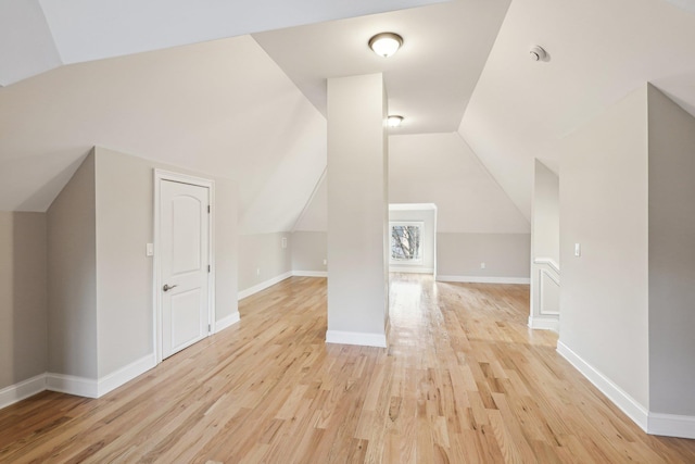 bonus room with lofted ceiling and light hardwood / wood-style flooring