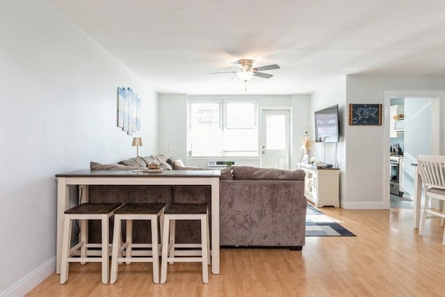 living room with ceiling fan and light hardwood / wood-style flooring