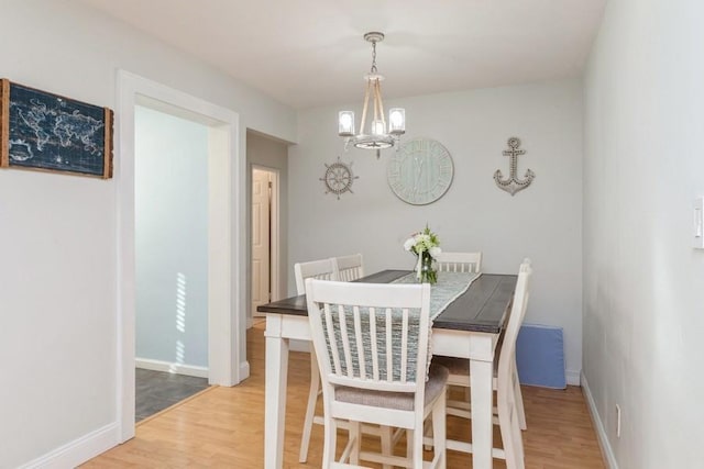 dining area featuring hardwood / wood-style flooring and a chandelier