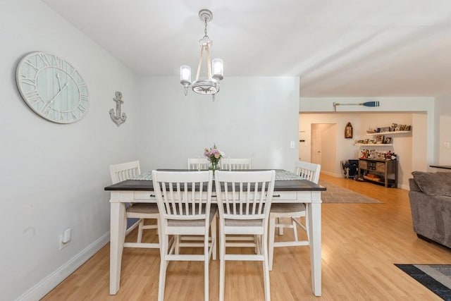 dining area featuring hardwood / wood-style floors and an inviting chandelier