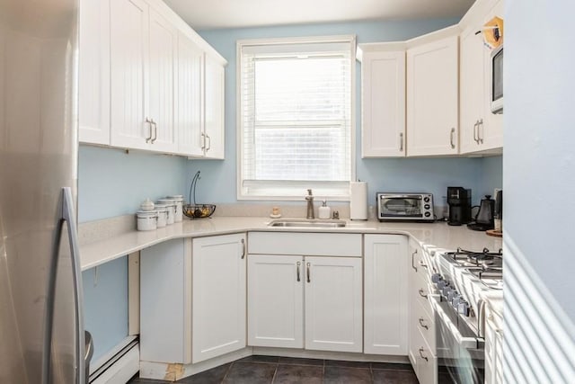 kitchen featuring white cabinetry, sink, appliances with stainless steel finishes, and a baseboard radiator