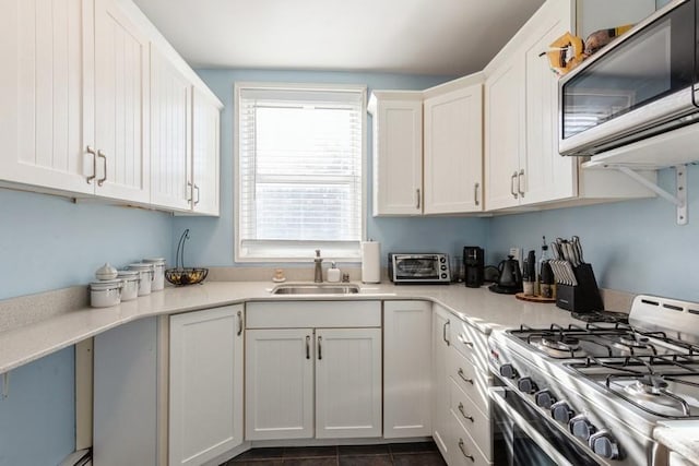 kitchen with white cabinets, sink, and stainless steel gas range