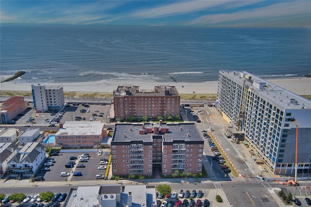 drone / aerial view featuring a beach view and a water view