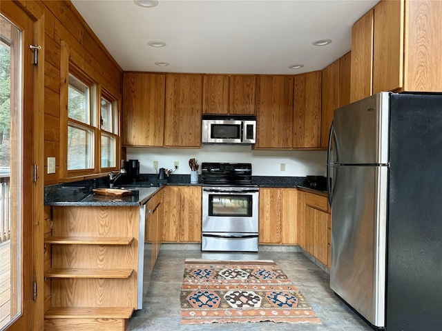 kitchen featuring dark stone countertops, sink, and appliances with stainless steel finishes