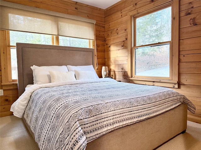 carpeted bedroom featuring wood walls