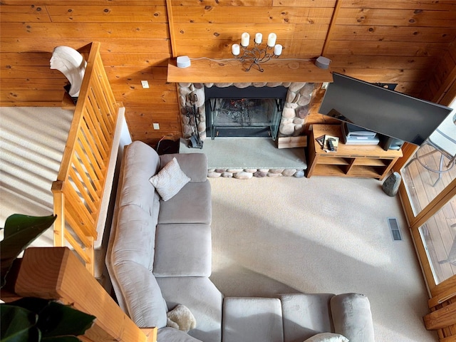 living room with carpet, wooden walls, beam ceiling, wooden ceiling, and a fireplace