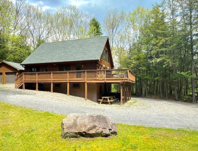 view of front facade with a deck and a front lawn