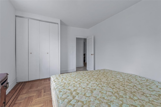 unfurnished bedroom featuring a closet and parquet flooring