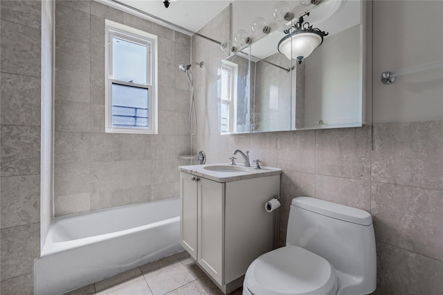 full bathroom featuring tiled shower / bath combo, tile patterned flooring, toilet, vanity, and tile walls