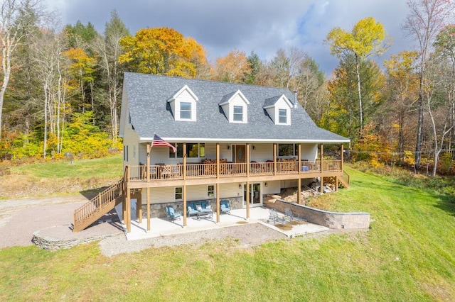 rear view of property with a yard, a patio, and a deck