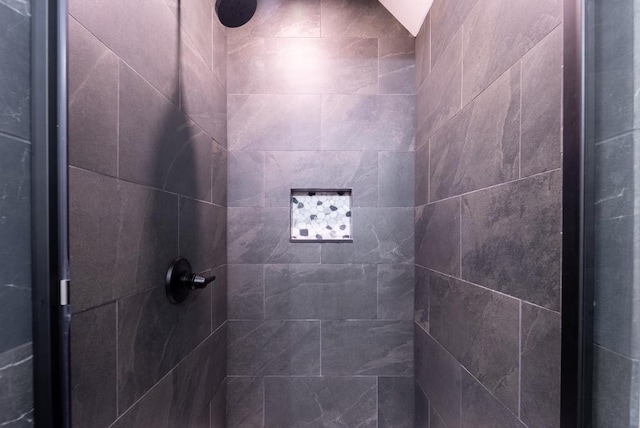 bathroom featuring tiled shower and vaulted ceiling