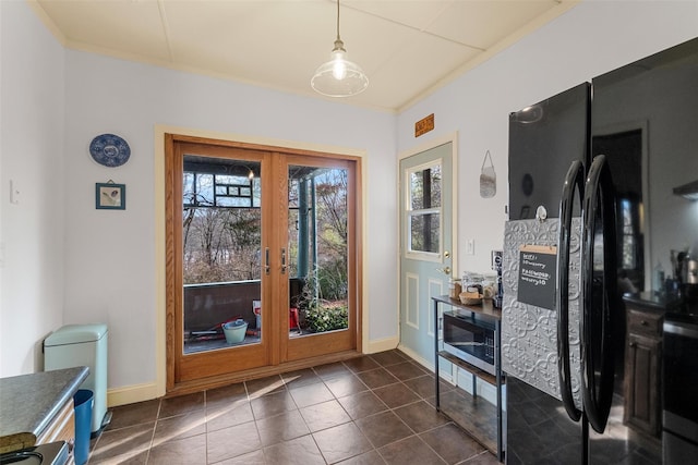 doorway to outside with baseboards, dark tile patterned flooring, and french doors