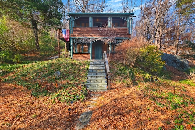 view of front of home featuring a sunroom and stairs