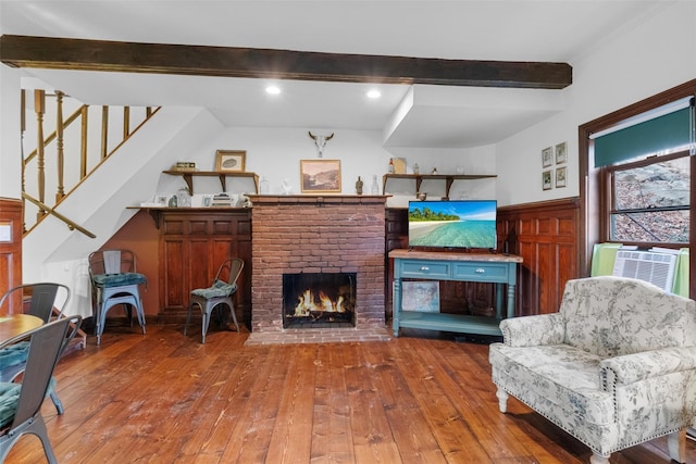 living room featuring cooling unit, a fireplace, stairway, hardwood / wood-style floors, and beamed ceiling