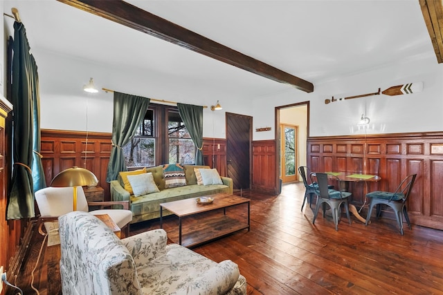 living area featuring dark wood-style floors, beamed ceiling, and wainscoting