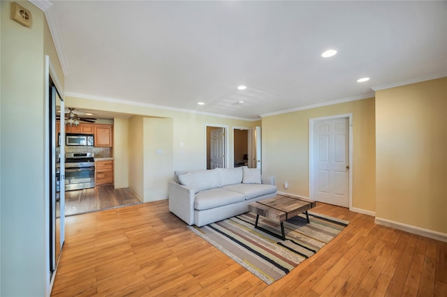 living room featuring ceiling fan, crown molding, and light hardwood / wood-style flooring