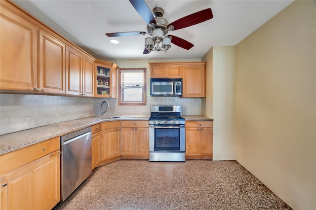 kitchen with stainless steel appliances, sink, decorative backsplash, and ceiling fan